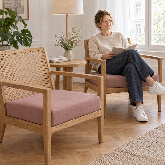 Lezende vrouw in een eikenhouten loungestoel met Weens vlechtwerk, ernaast een stoel met lounge zitkussen op maat van structuurstof in flamingoroze